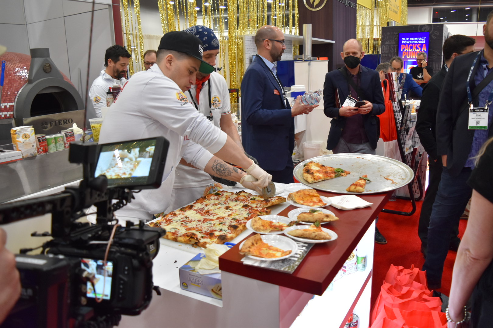 Pizzaioli Cutting a Roman Style Pizza in the Orlando Booth