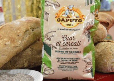 A bag of Caputo Cereali in front of bread made by Jonathan Goldsmith with the flour next to a plate of the raw flour
