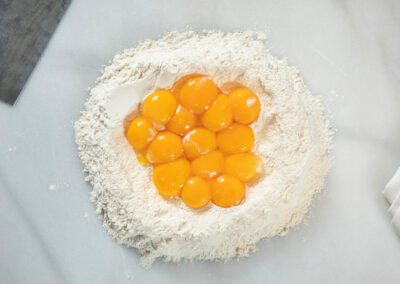A pile of flour with egg yolks in the middle