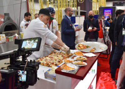Pizzaioli Cutting a Roman Style Pizza in the Orlando Booth