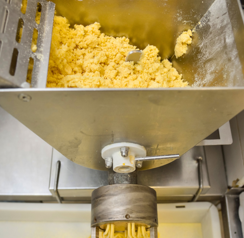 Extruded pasta dough in a commercial pasta extruder